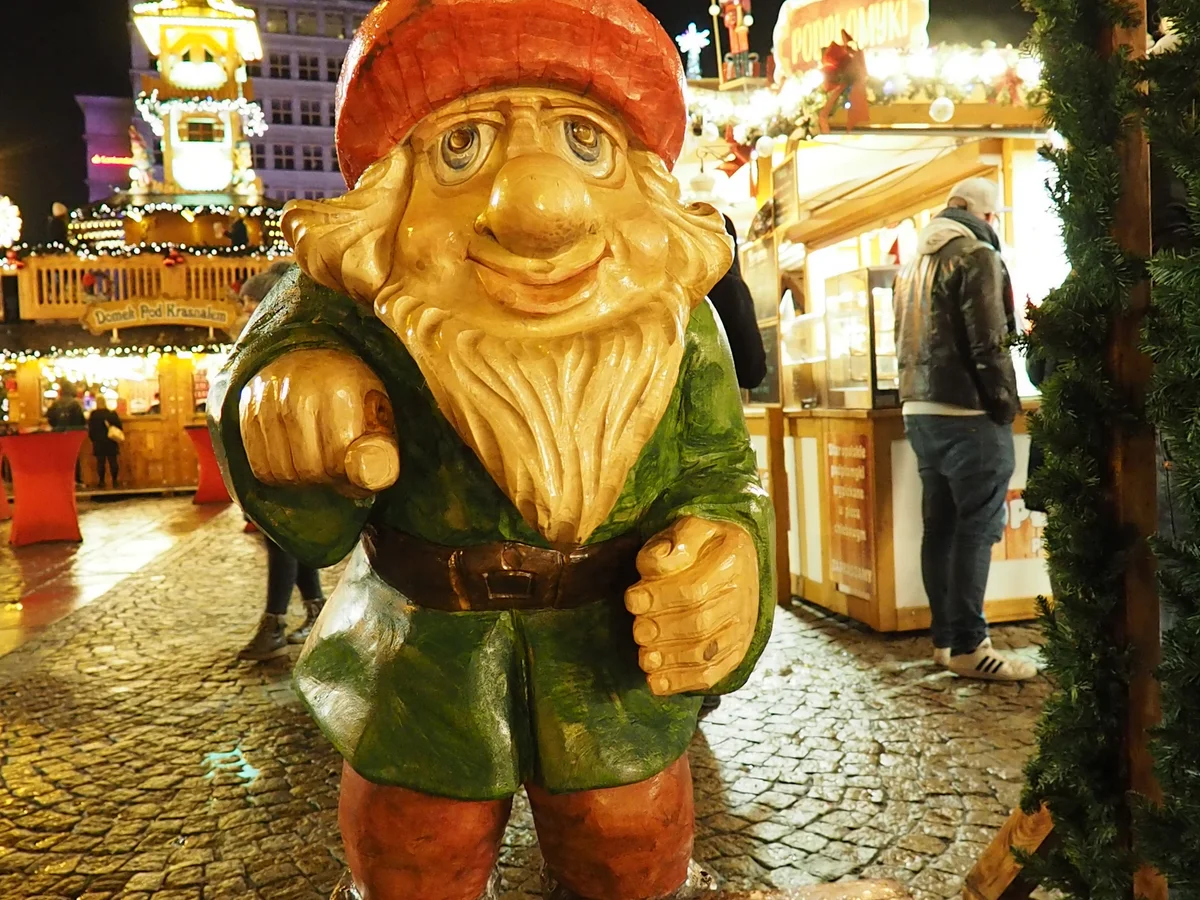 Wroclaw dwarf figure shines warmly in festive Christmas market atmosphere