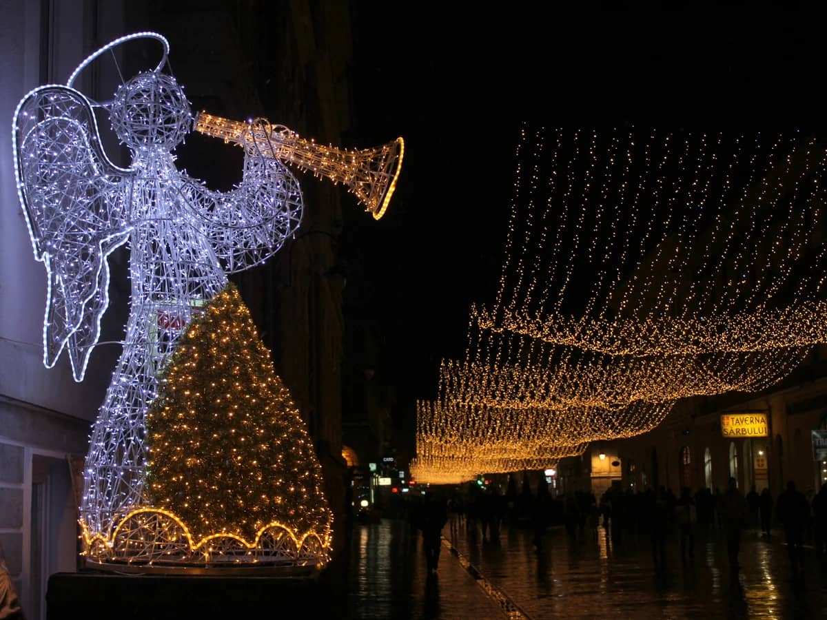 Brasov illuminated angel decoration and Christmas tree in winter evening
