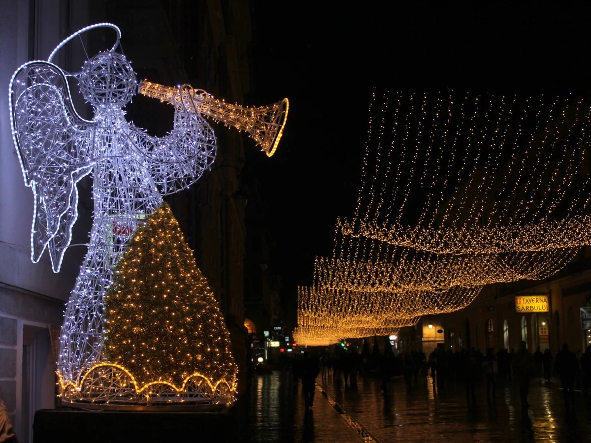 Brasov illuminated angel decoration and Christmas tree in winter evening