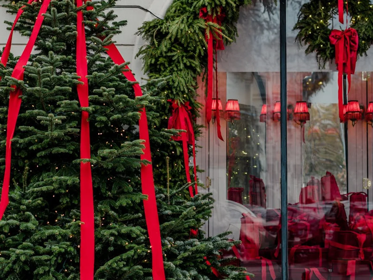 Bucharest elegant storefront adorned with festive red ribbons and evergreen garland in winter season