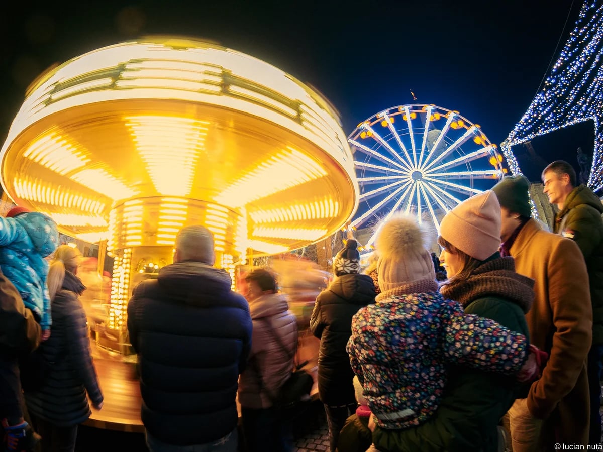 Cluj-Napoca Christmas market carousel and Ferris wheel at blue hour