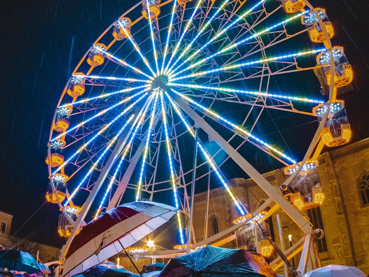 Cluj-Napoca illuminated Ferris wheel in a rainy Christmas market ambiance