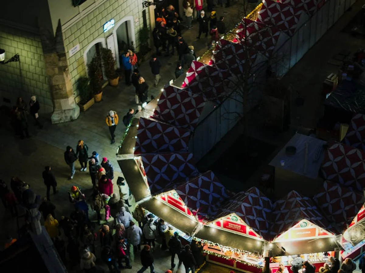 Aerial view of bustling Bratislava Christmas market at night with festive lights