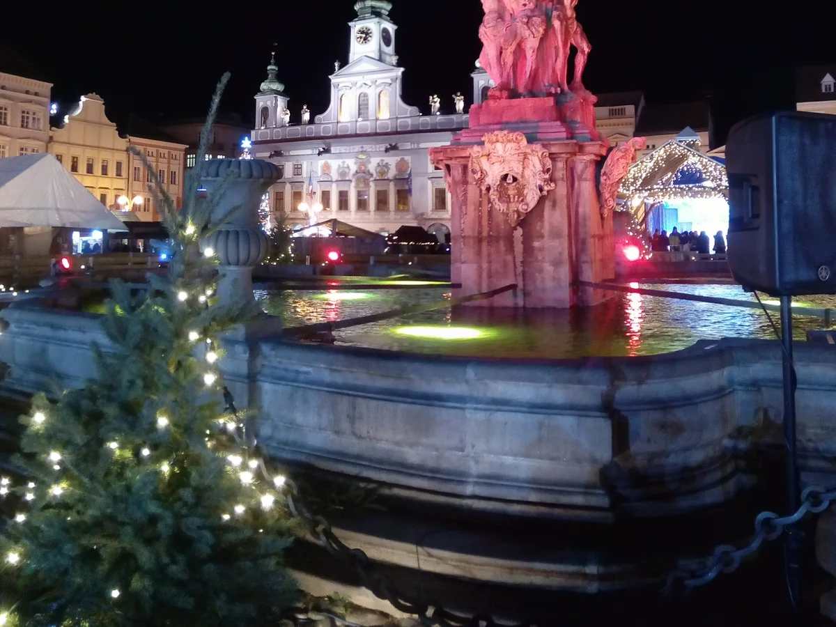 Čarobni Maribor - Main Square illuminated Plague Monument at dusk with festive market atmosphere