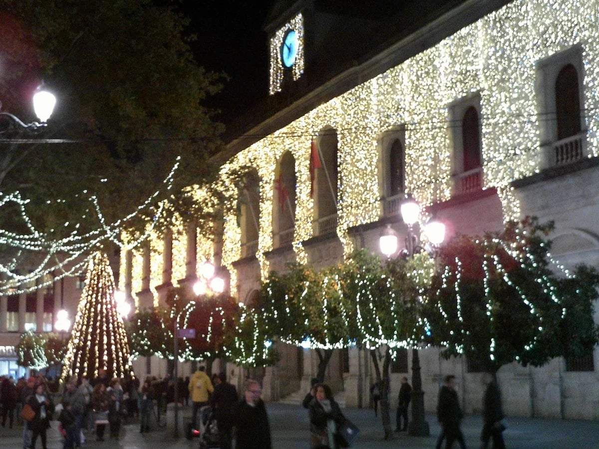 Seville Ayuntamiento adorned with golden lights in a festive winter atmosphere