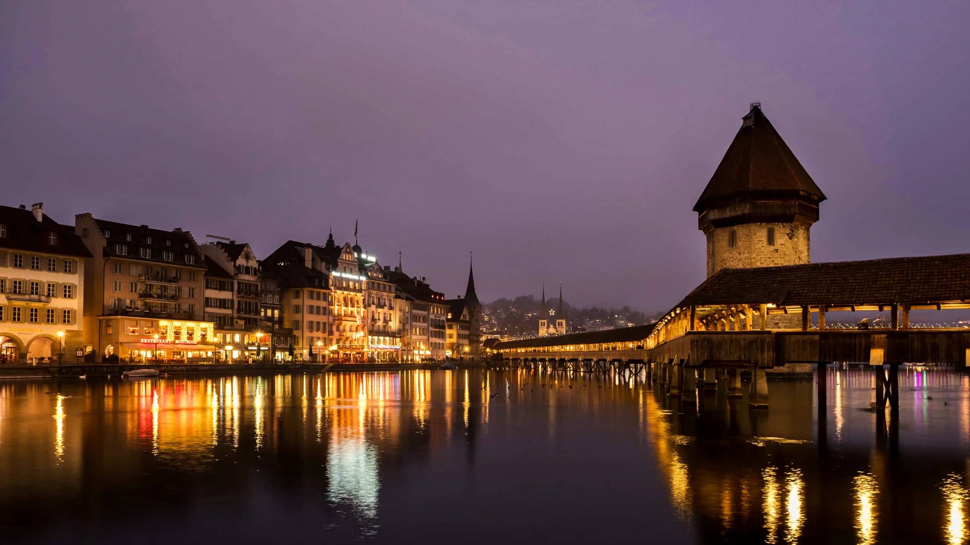 Lucerne Chapel Bridge illuminated in winter twilight ambiance