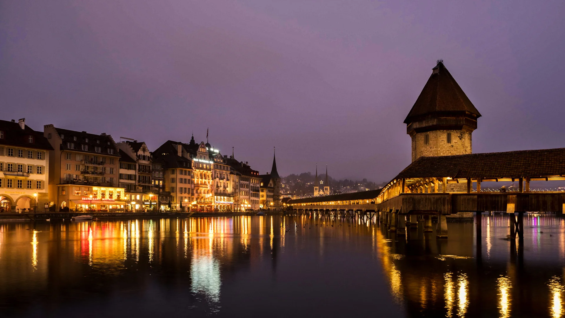 Lucerne Chapel Bridge illuminated in winter twilight ambiance