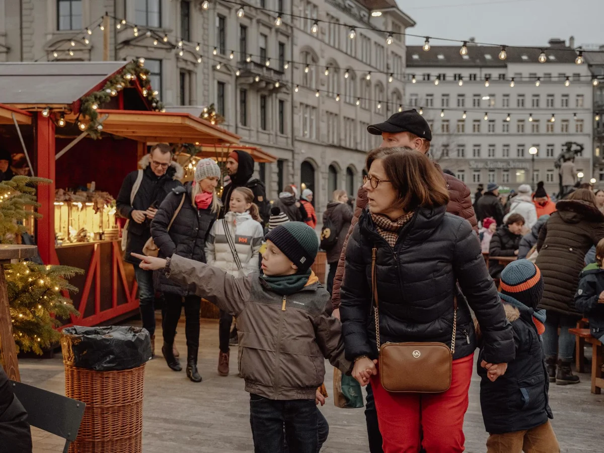 Zurich Christmas market stalls glowing under winter sun