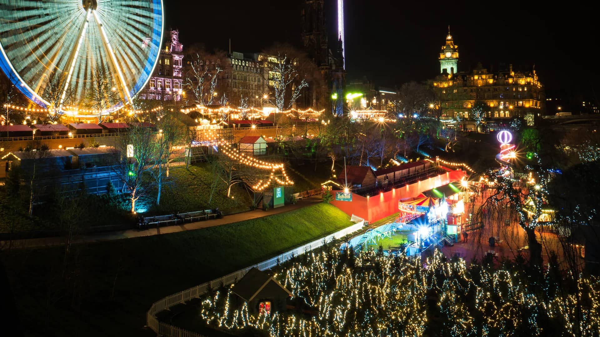 Edinburgh Christmas market illuminated at blue hour featuring iconic landmarks