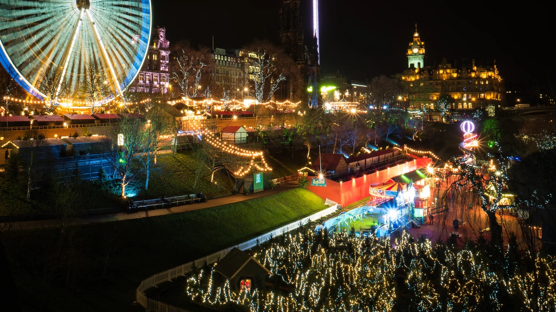 Edinburgh Christmas market illuminated at blue hour featuring iconic landmarks