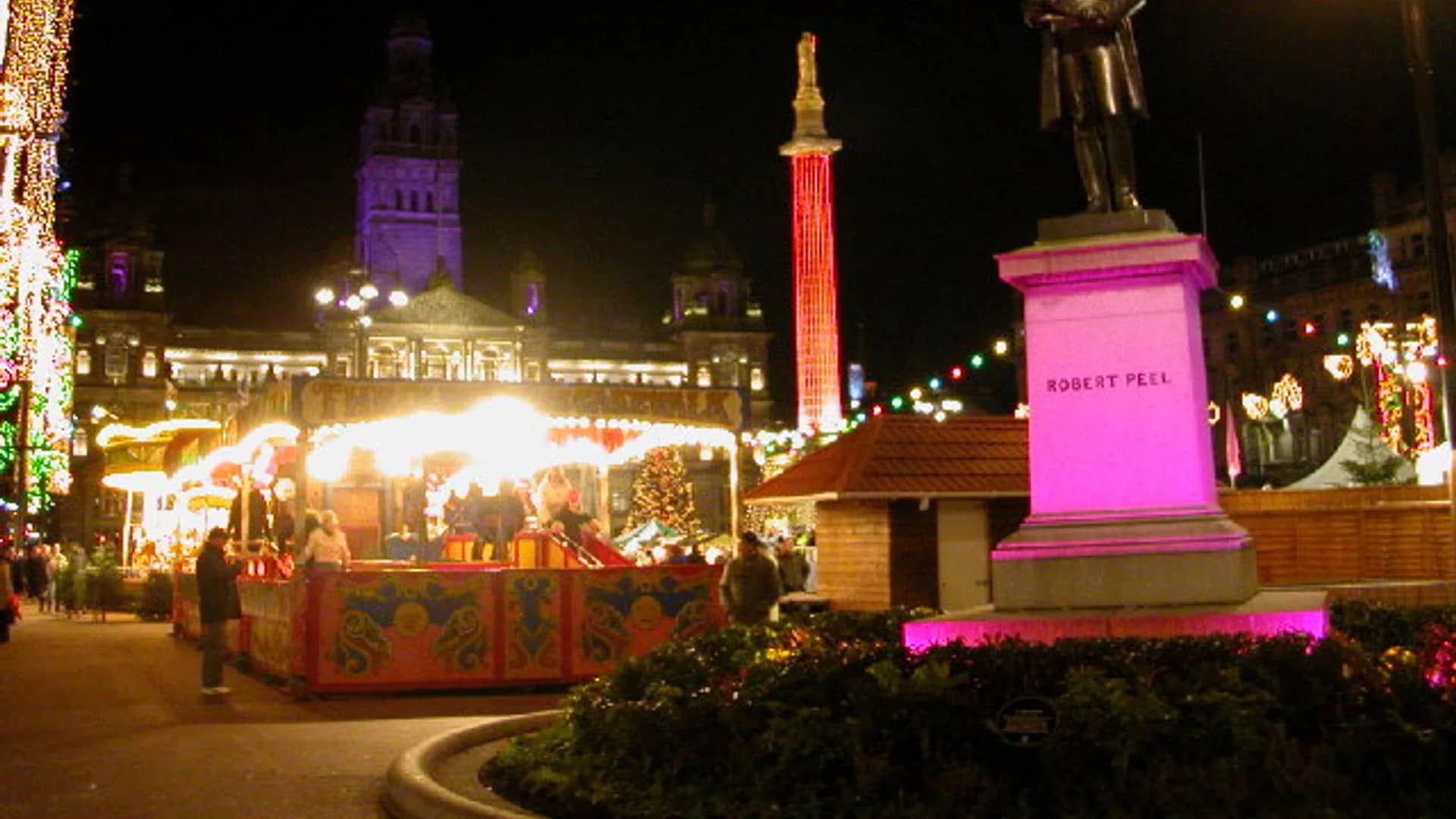 Glasgow George Square Christmas market with festive stalls and Scott Monument