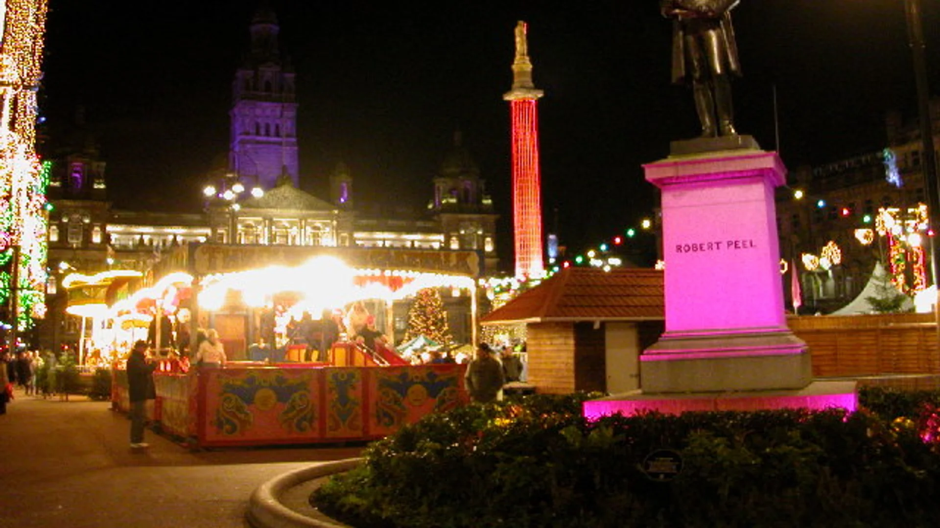 Glasgow George Square Christmas market with festive stalls and Scott Monument