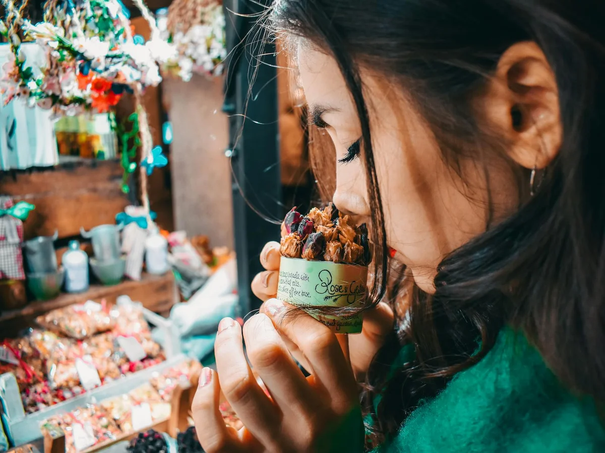London visitor enjoying festive treats at a Christmas market during winter