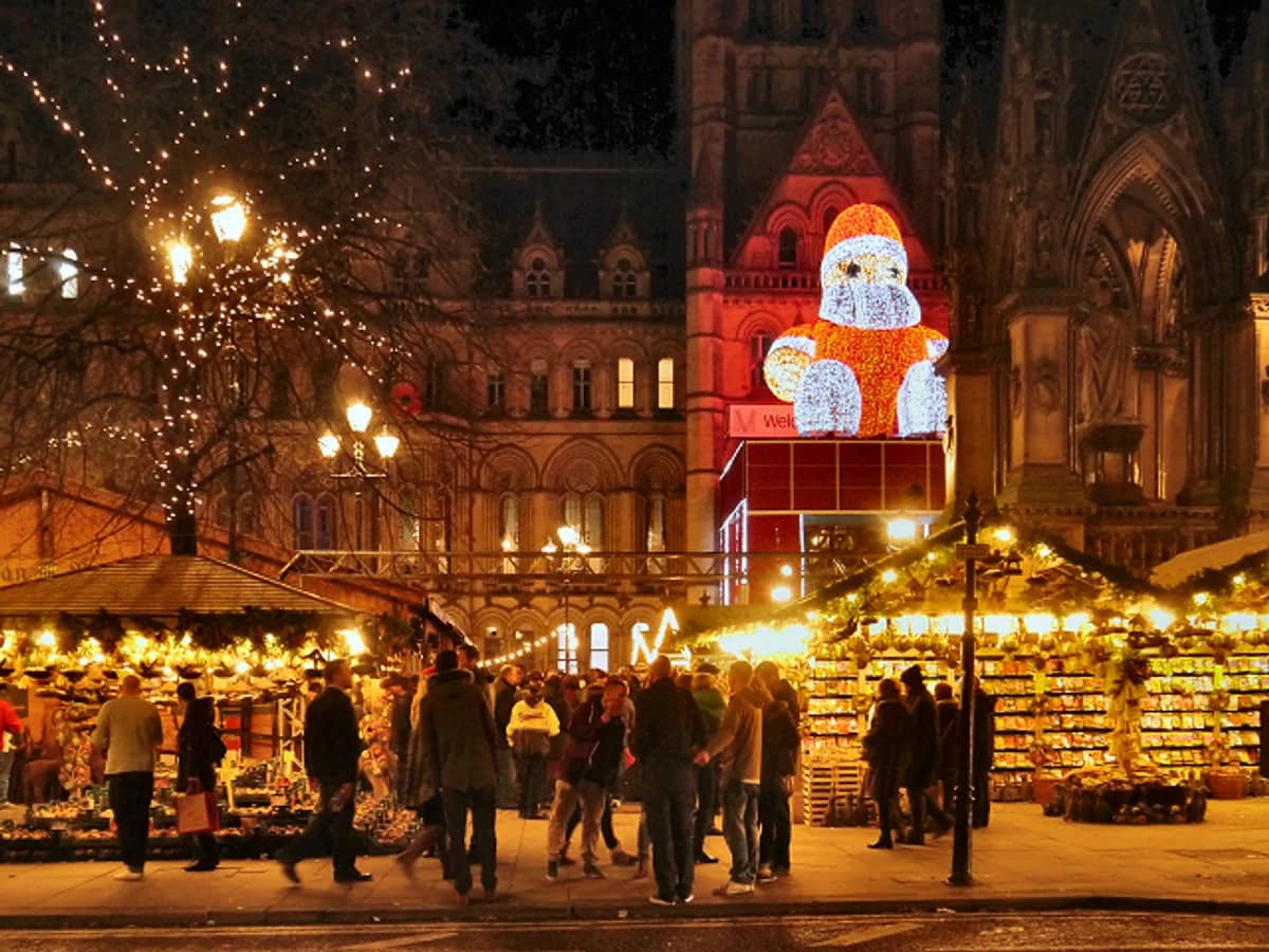 Manchester Christmas market at dusk with iconic architecture and festive Santa