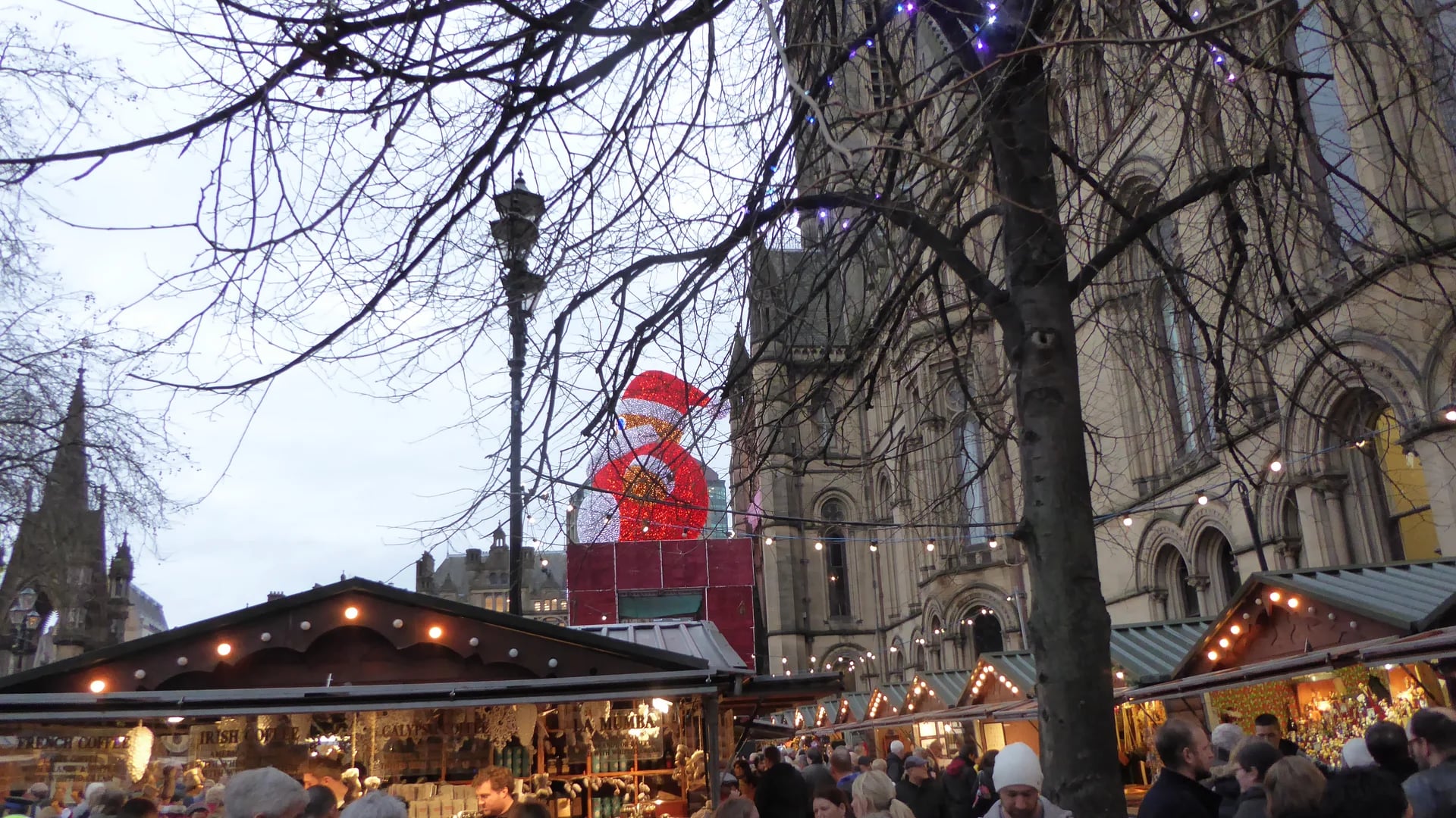 Manchester Christmas market with Gothic Cathedral and giant Santa figure