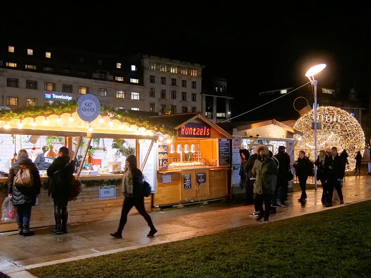 Manchester bustling Christmas market with festive stalls and illuminated decorations