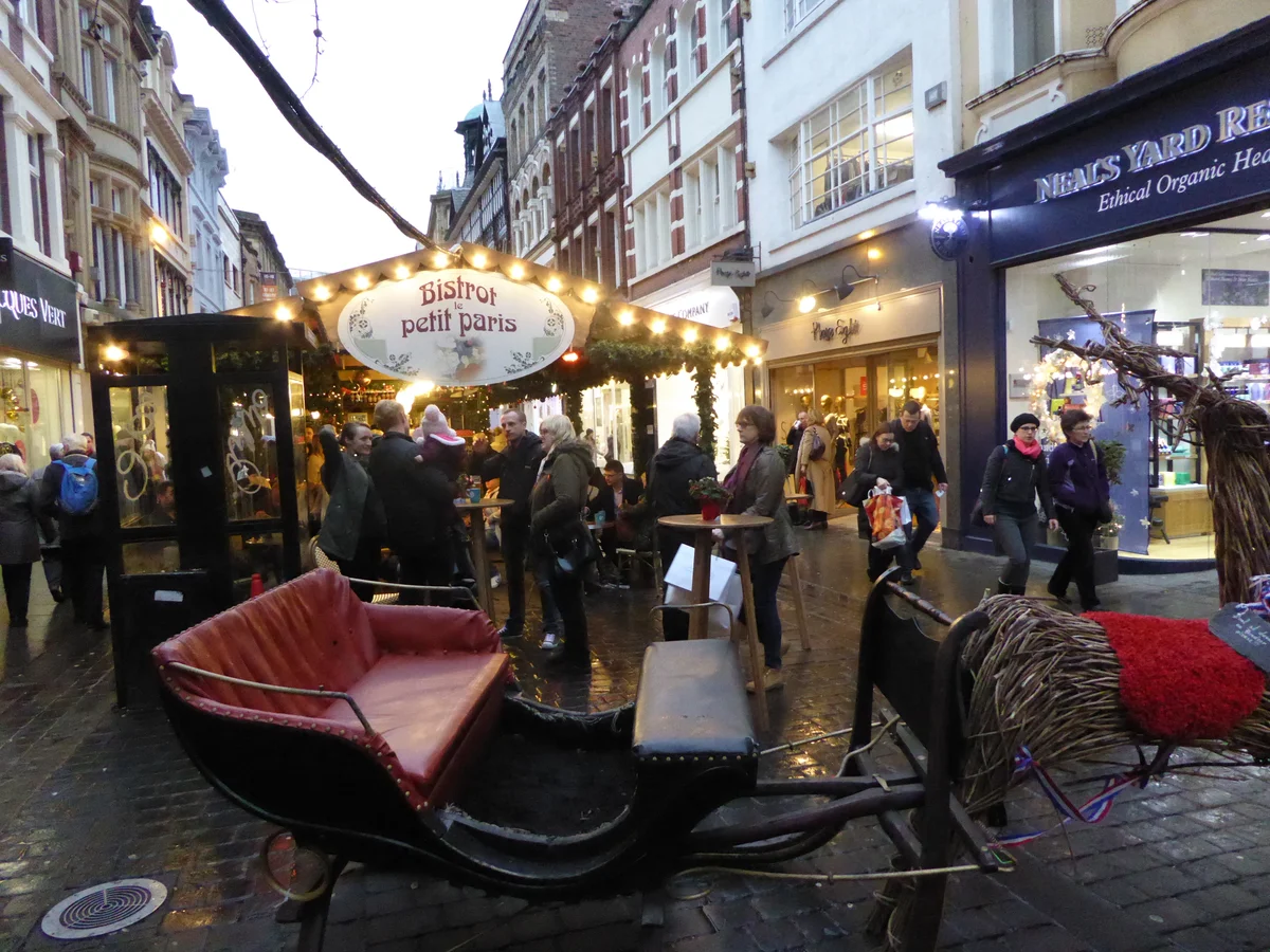 Manchester Christmas market scene with festive stalls and warm evening lights