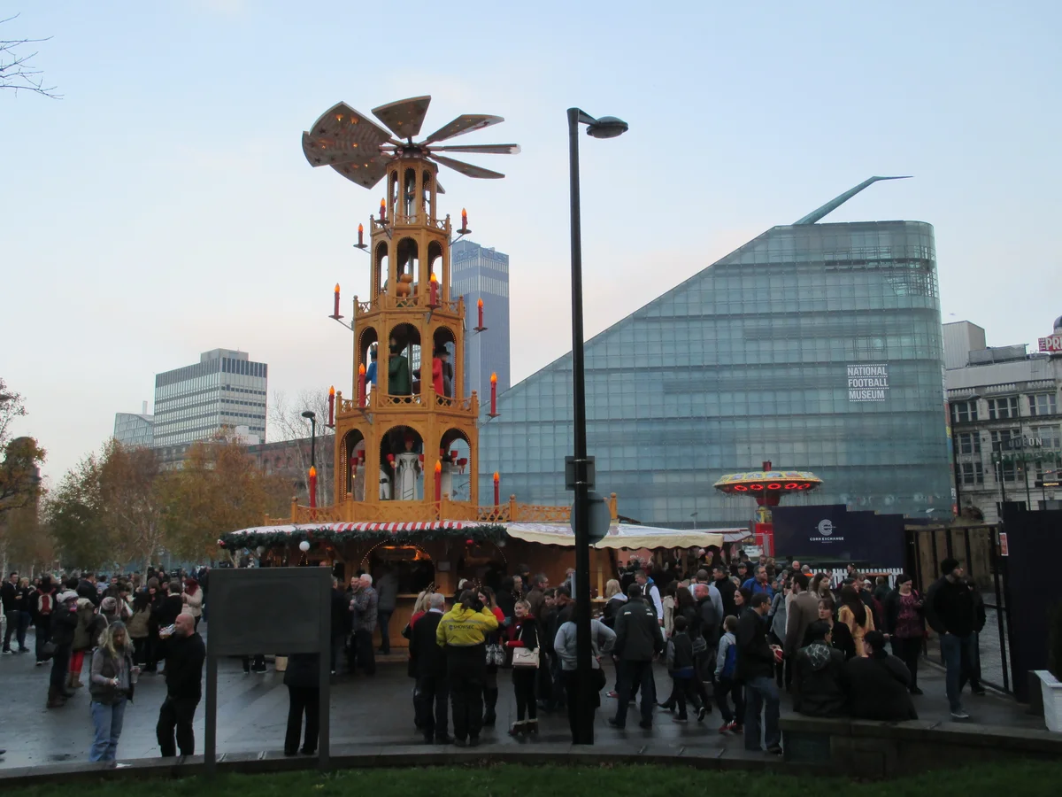 Manchester's iconic Christmas pyramid amidst a bustling winter market scene