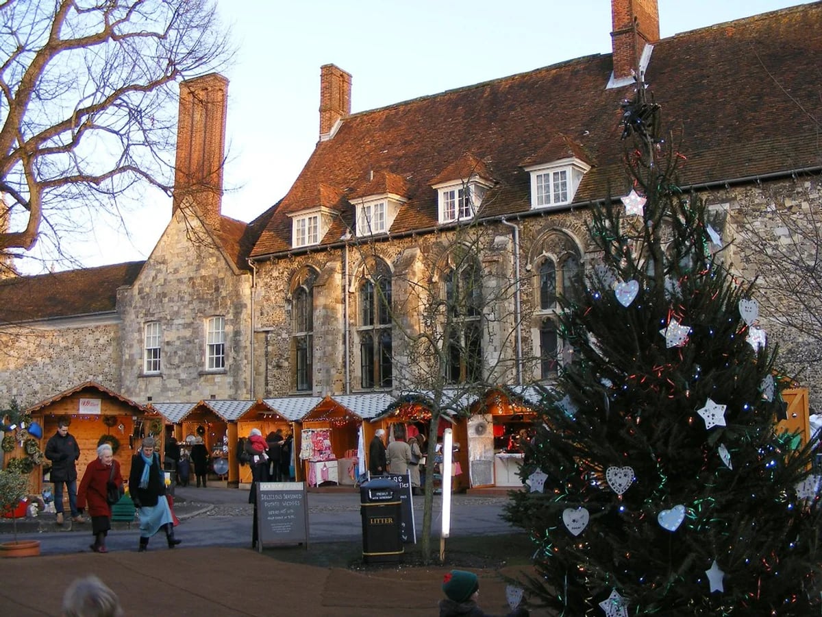 Winchester Cathedral Christmas Market stalls and decorated tree in Winchester's historic atmosphere at The Close