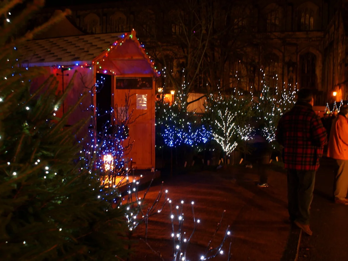 Winchester Cathedral Christmas Market illuminated at twilight in Winchester, showcasing festive stalls and iconic architecture.
