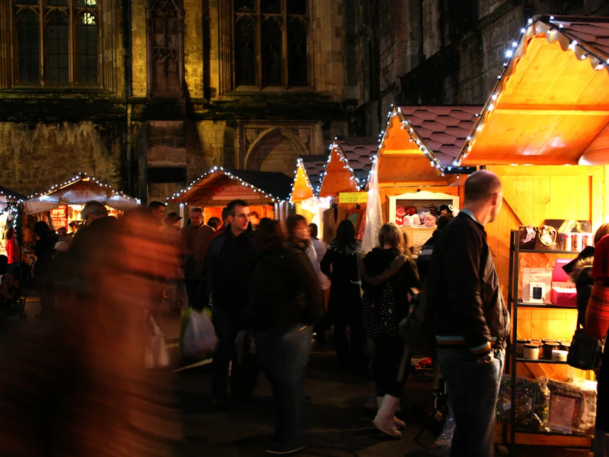 Winchester Cathedral Christmas Market glowing stalls evening ambiance Winchester festive atmosphere Gothic architecture